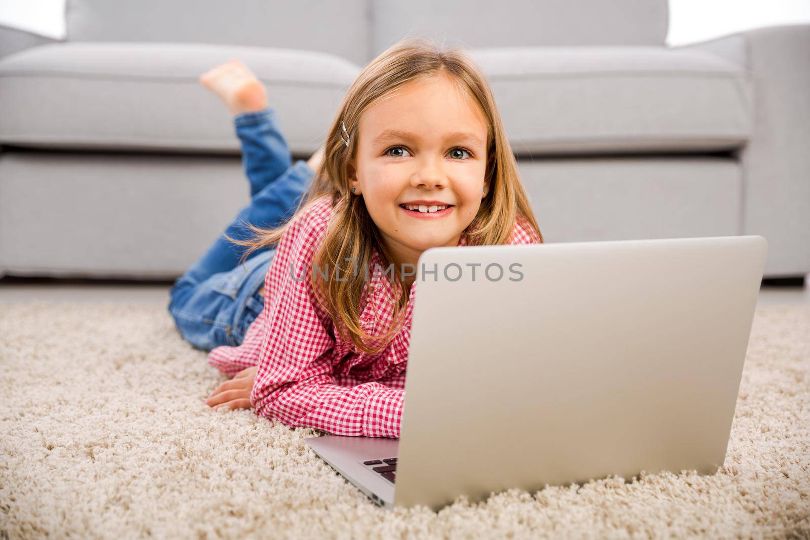 Little girl working with a laptop by Iko