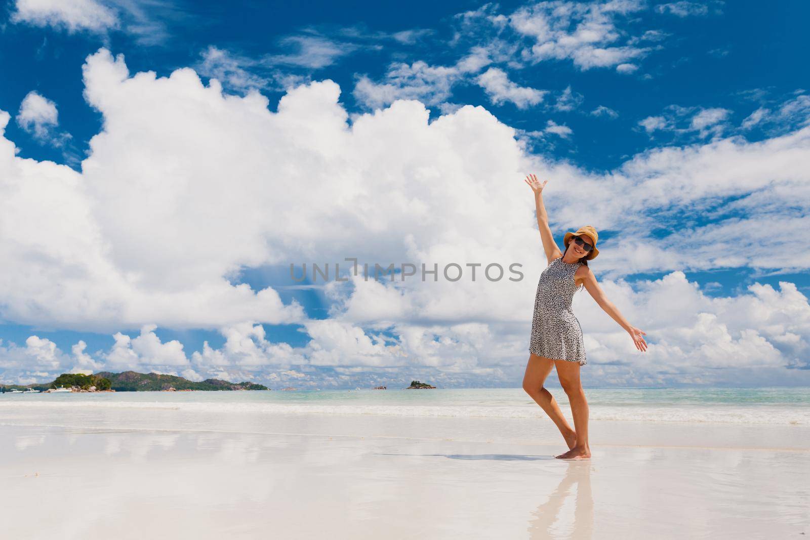 Beautiful woman on the beach enjoying the beauty of Praslin, Seychelles