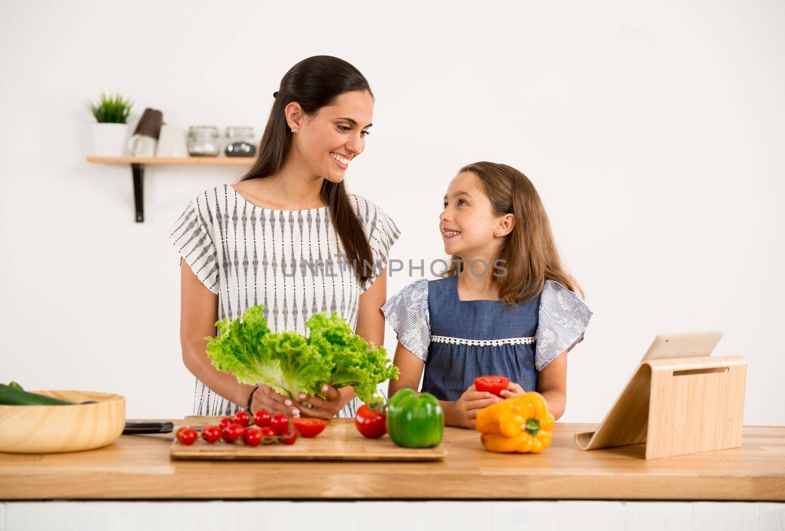 Shot of a mother and daughter having fun in the kitchen