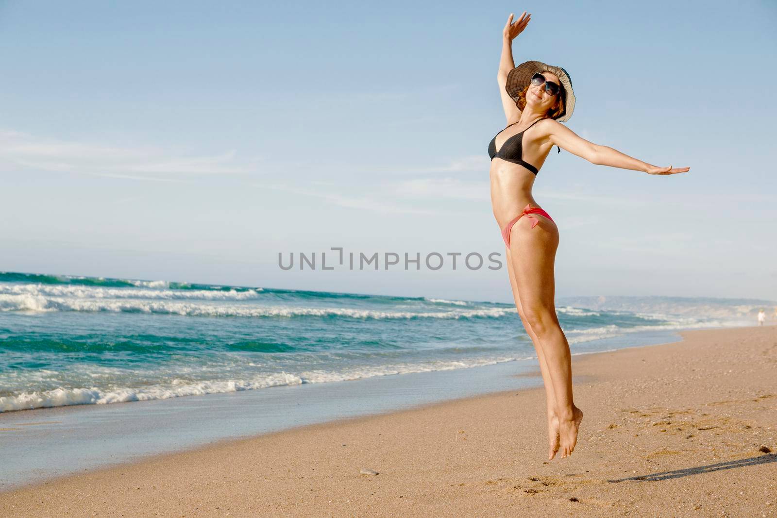 Beautiful woman jumping on the beach