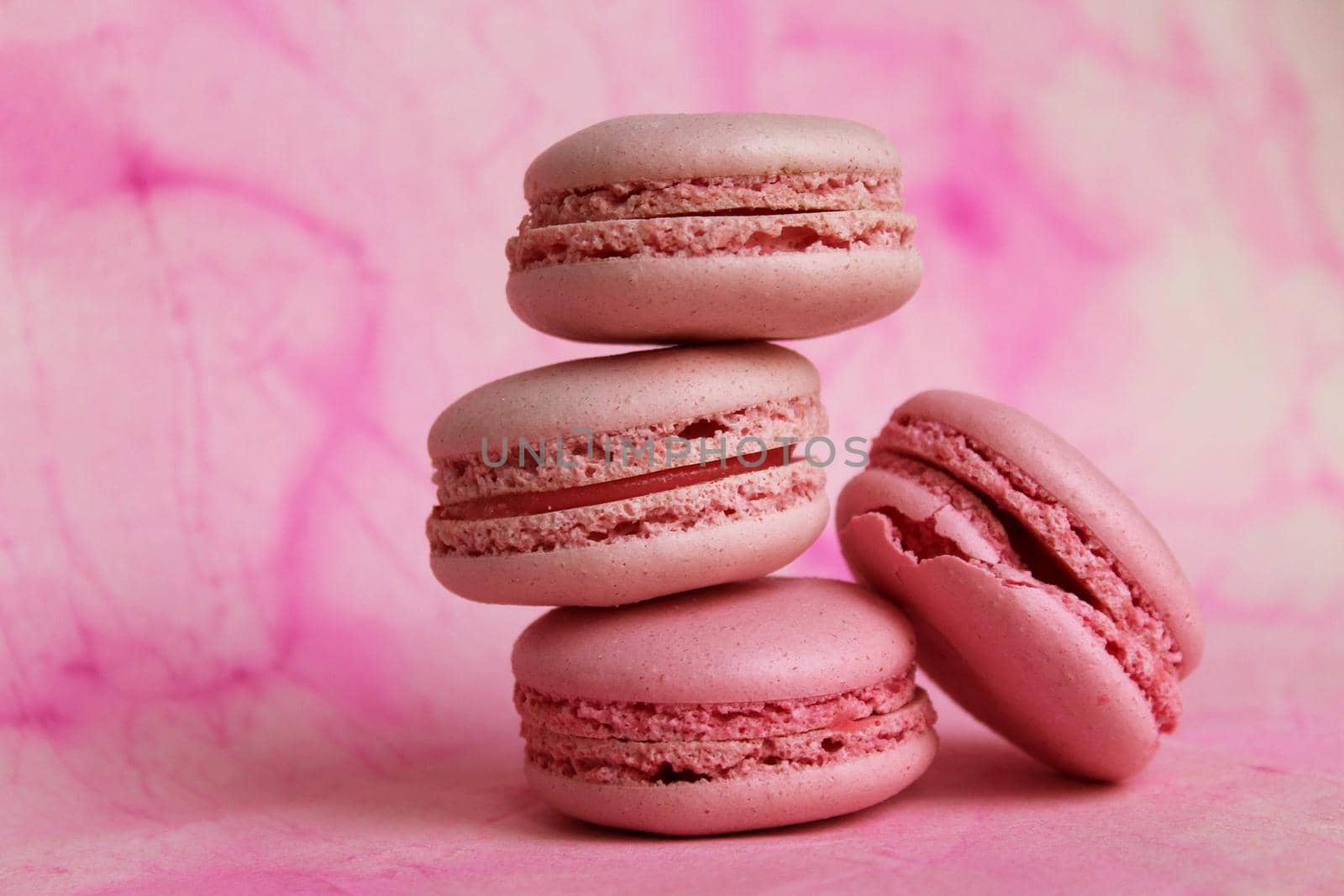 Stack of pink macarons on abstract watercolor background. Sweet food. Delicious pastries. Beautiful template with pink macaroon for wallpaper design.