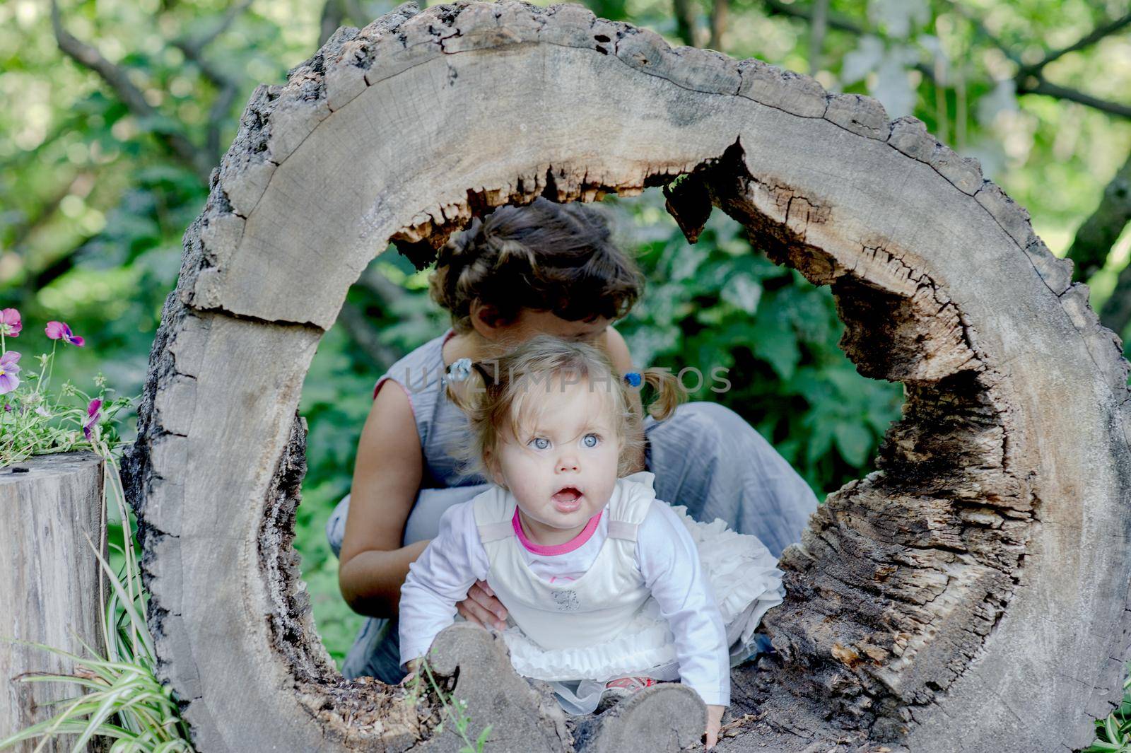 Two funny little girls having fun with a sleigh in beautiful park. High quality photo