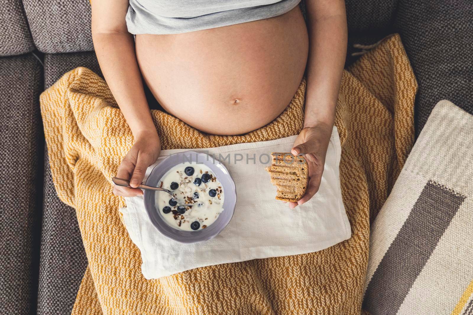 Pregnant woman eating healthy food at home