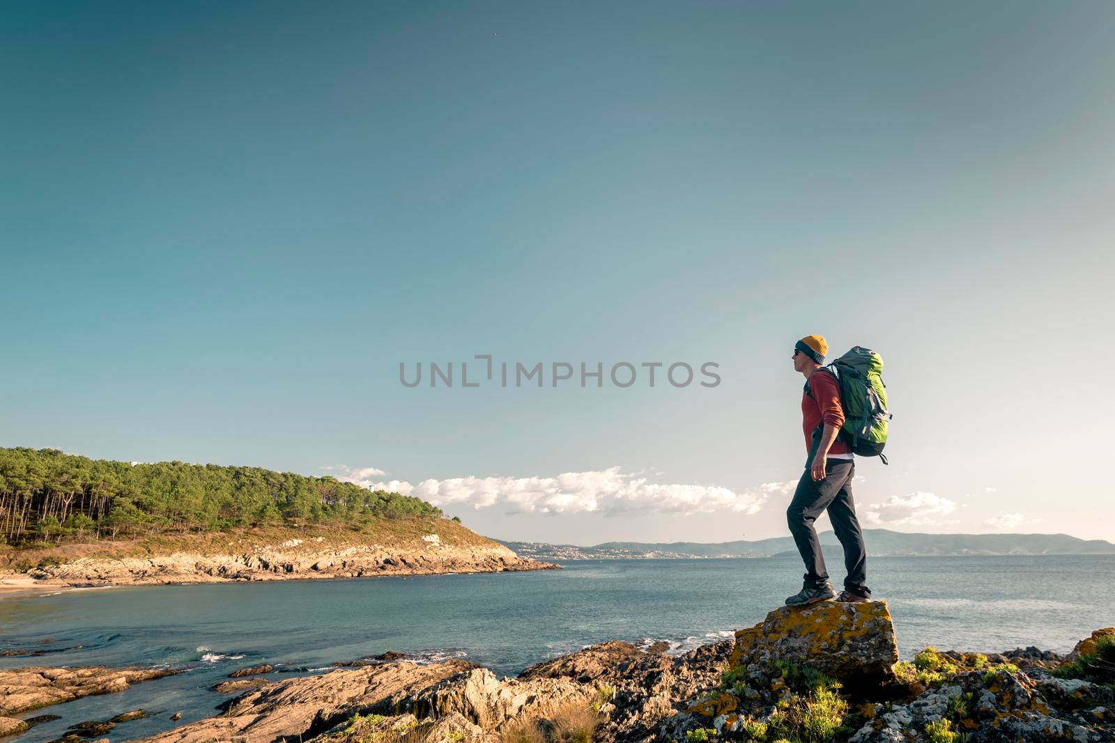 Shot of a man exploring the coastline with backpack