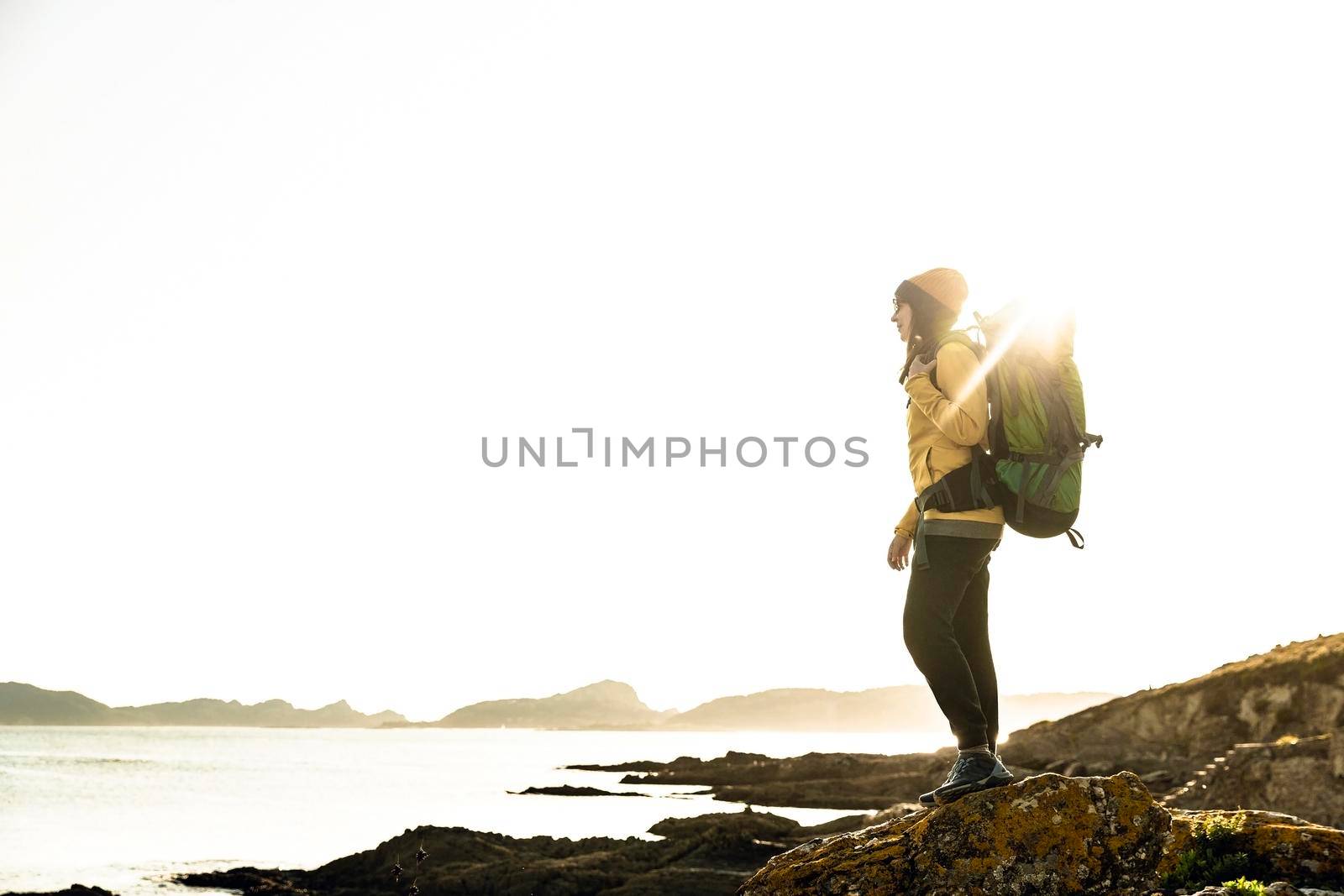 Shot of a woman exploring the coastline with backpack