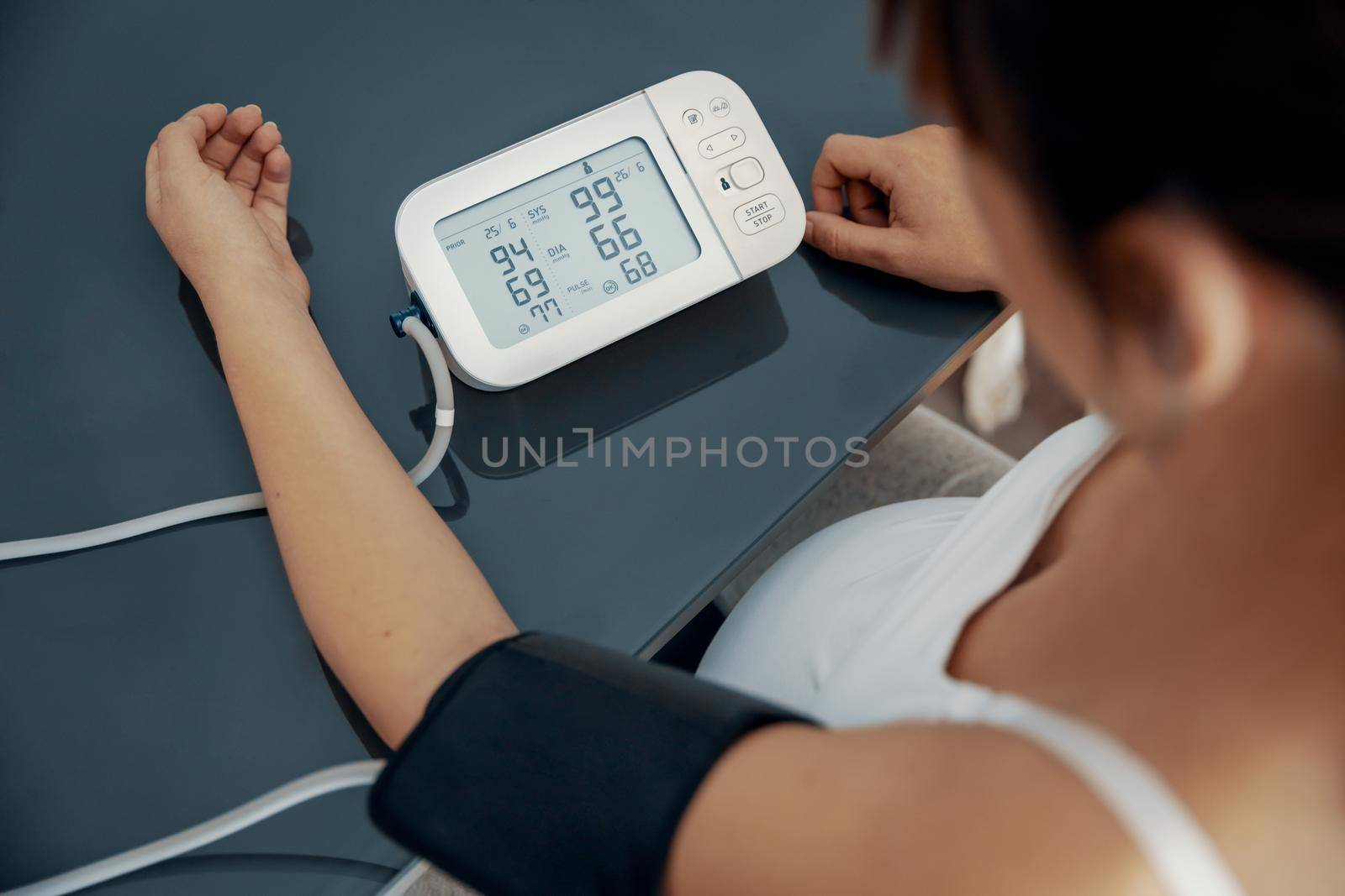 Pregnant woman measuring her blood pressure during the third trimester