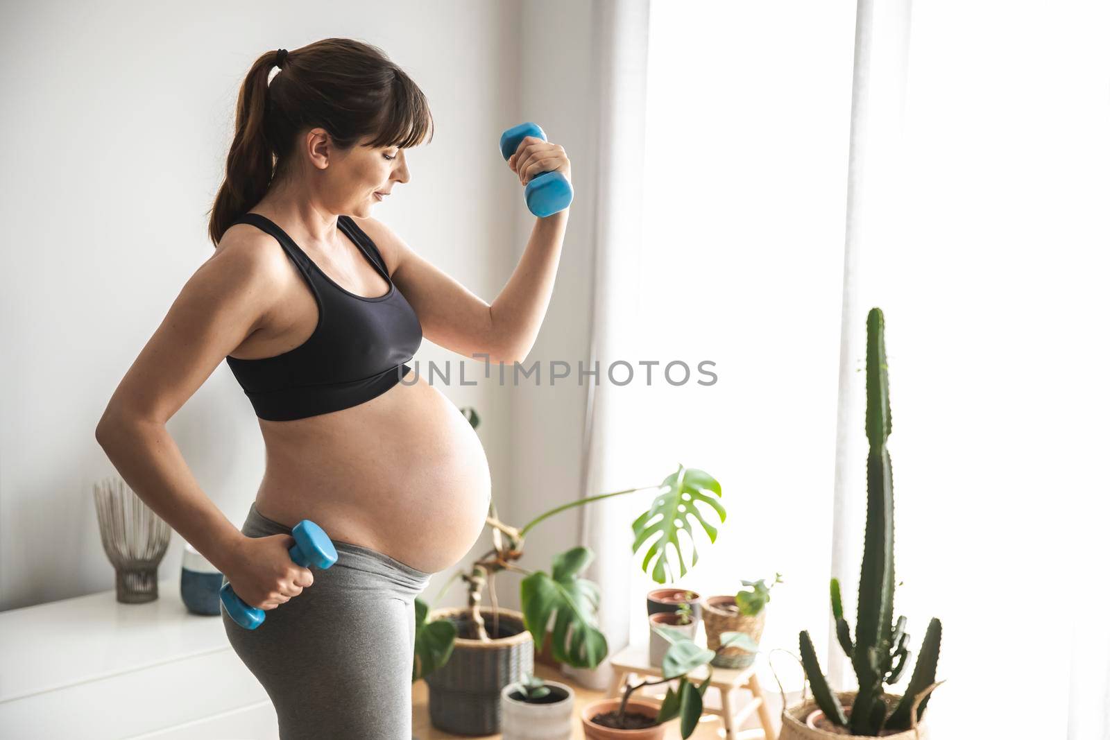 Pregnant woman doing exercises by Iko