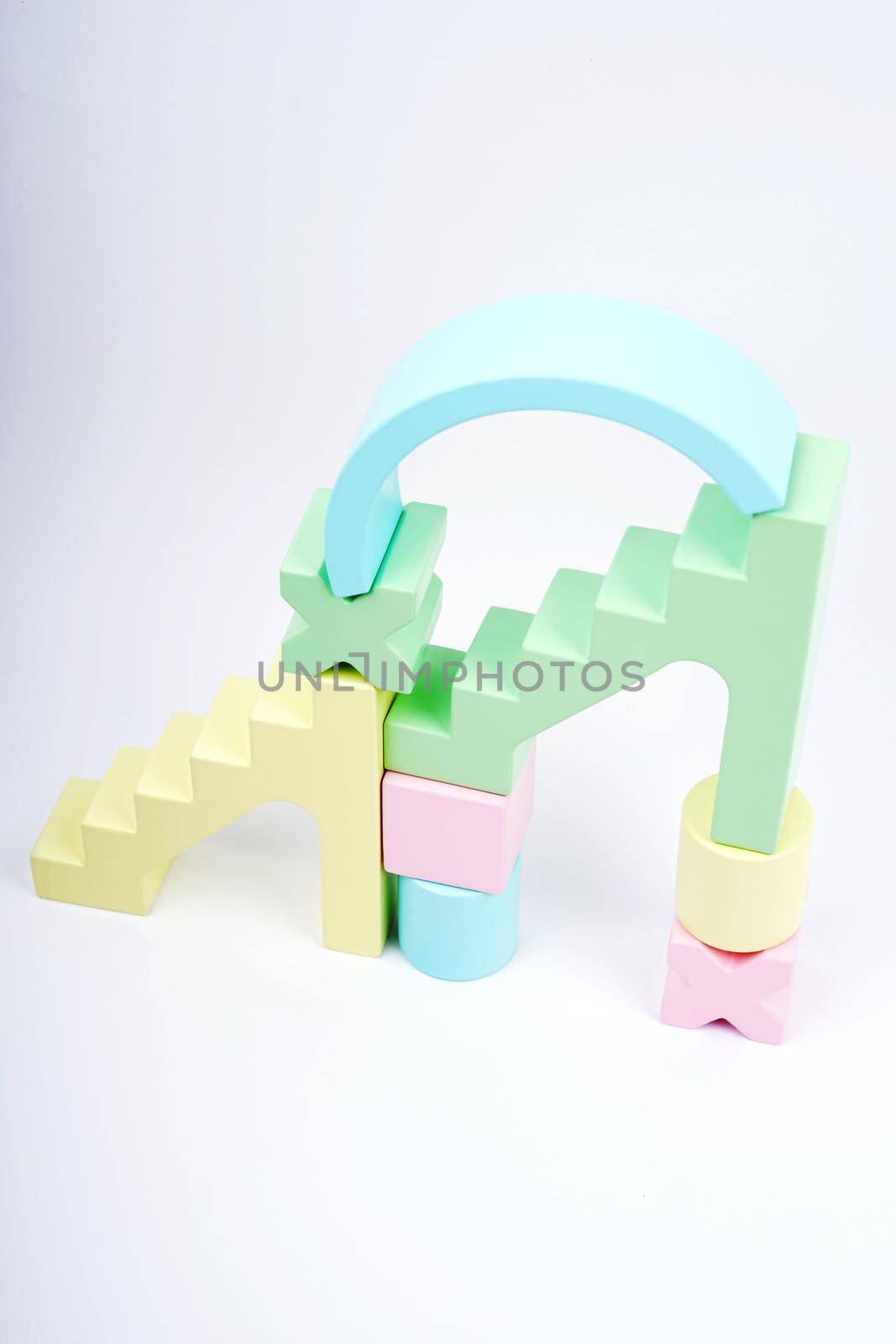 The composition is made of voluminous geometric shapes. Pastel gamma at wooden parts. Natural tree. Children's wooden construction.