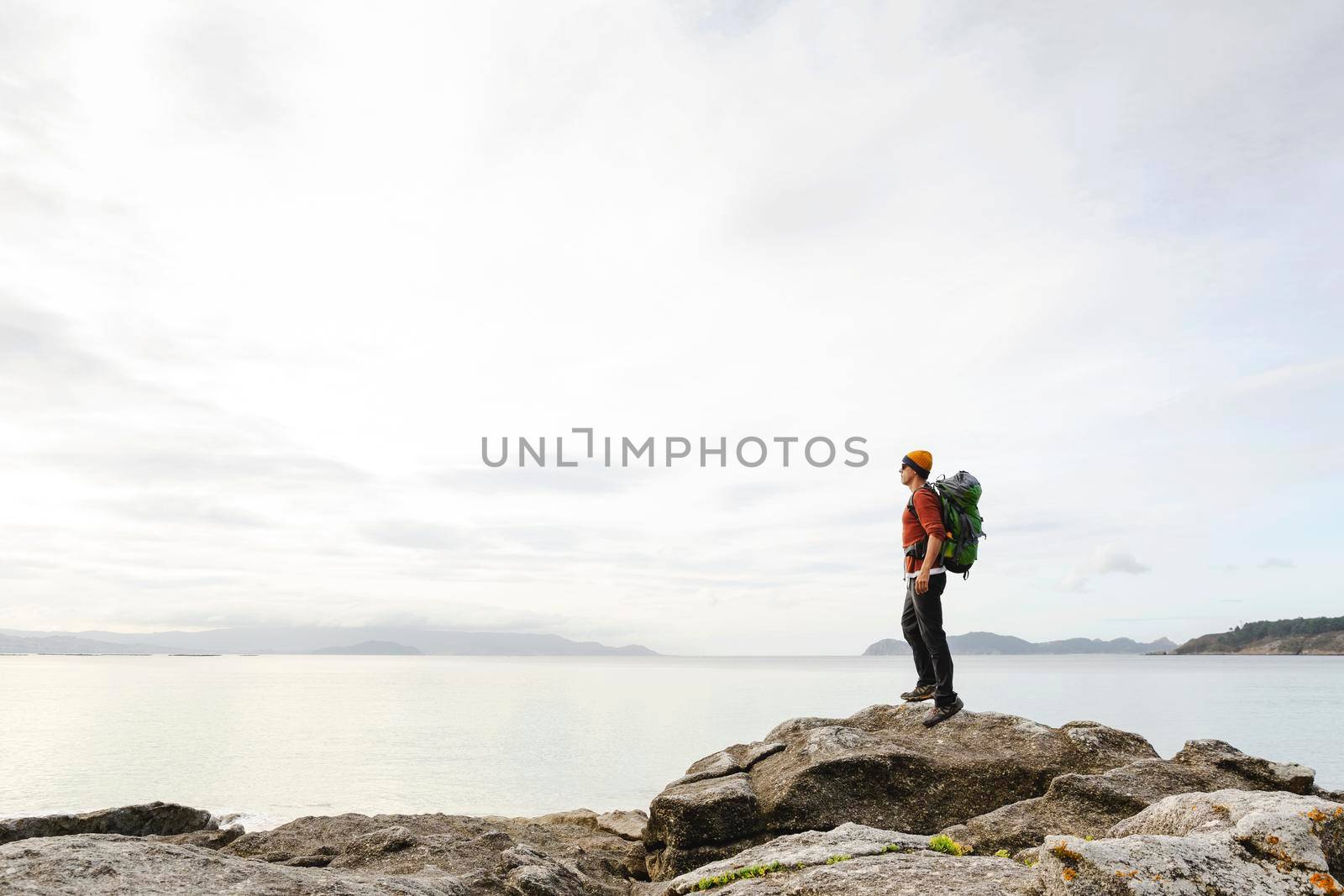 Man with backoack enjoying the morning view of the coast