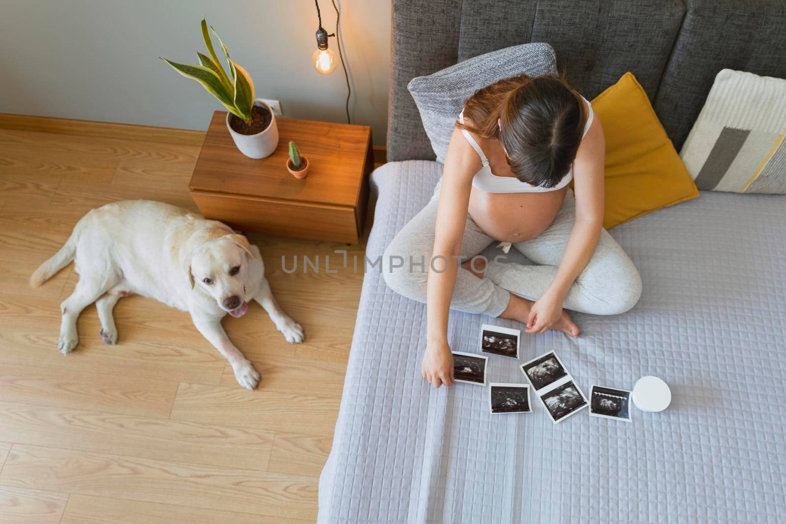 Pregnant woman looking to the pictures of the ultrasound, Prenatal health care concept.