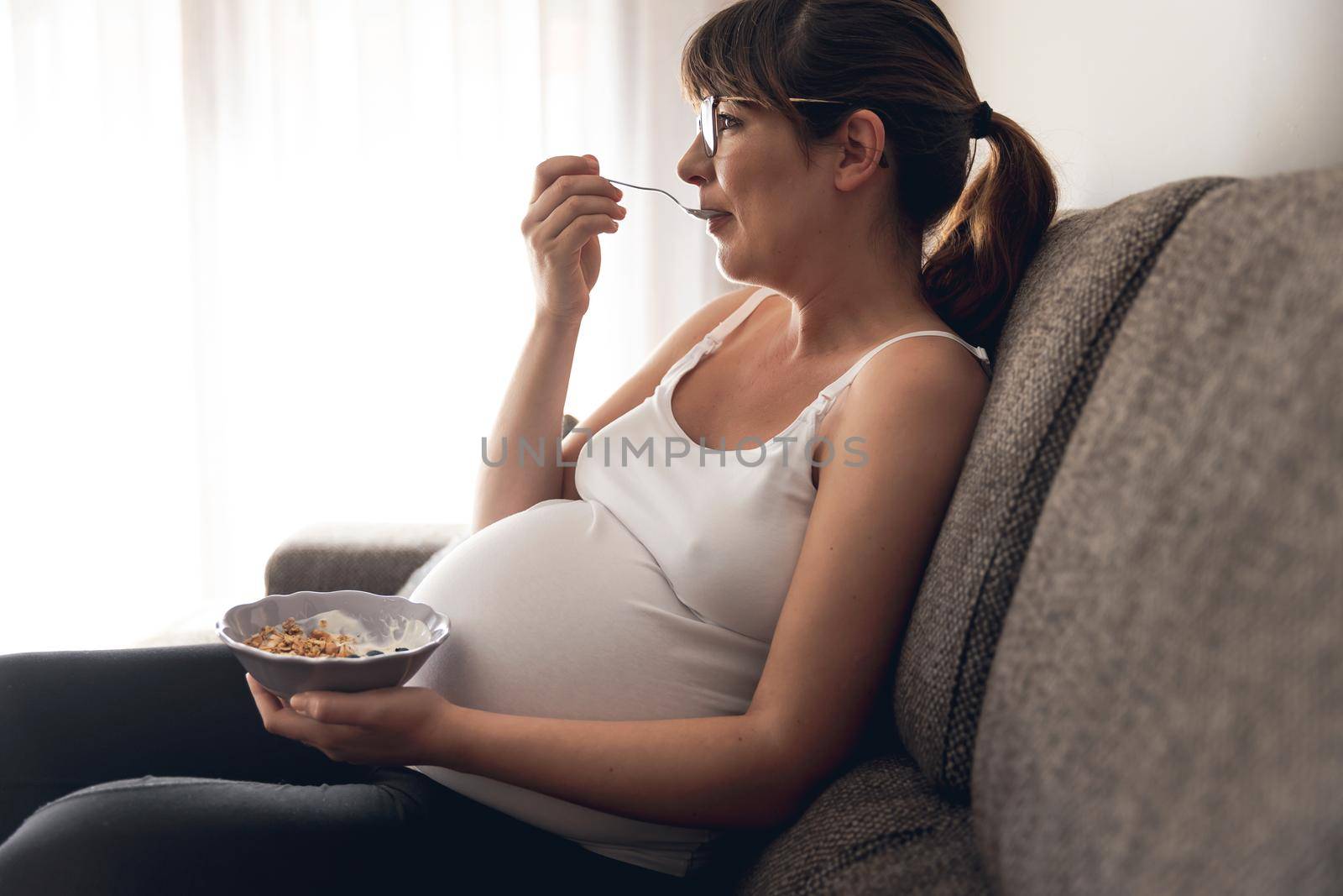 Pregnant woman working at home resting and eating healthy food