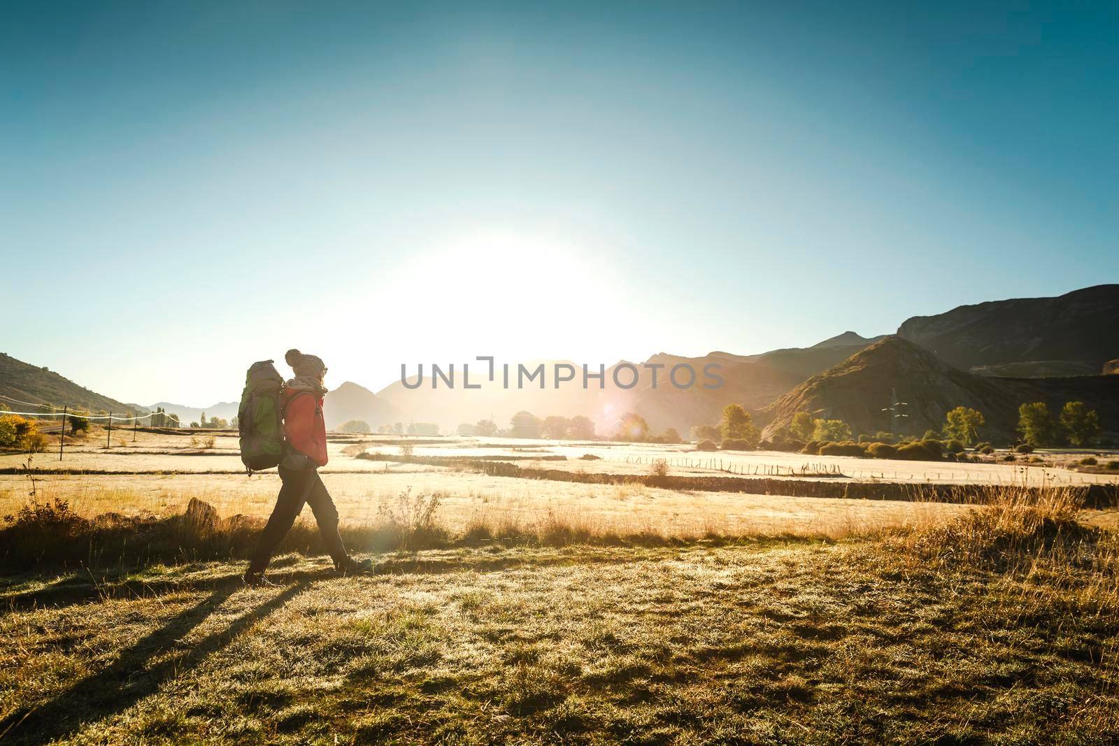 Woman walking with a backpack by Iko