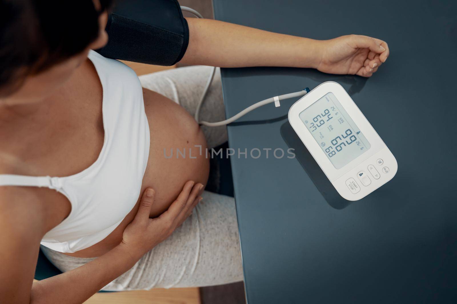 Pregnant woman measuring her blood pressure during the third trimester