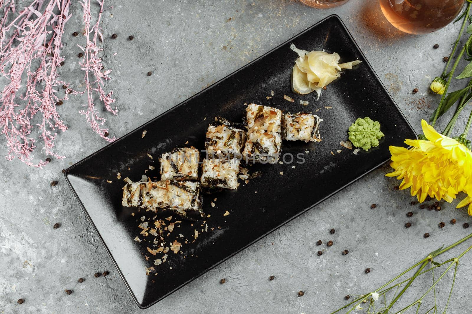 Golden dragon sushi roll with tuna, eel, cucumber, sesame seeds and tobiko caviar on wood background.
