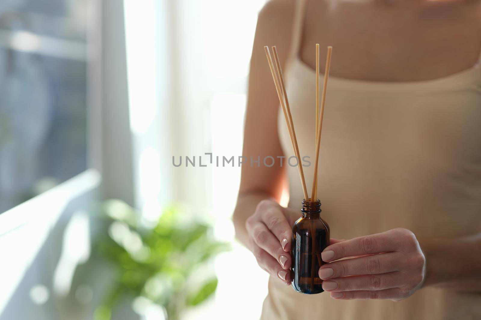 Romantic woman holding a diffuser with bamboo sticks by kuprevich