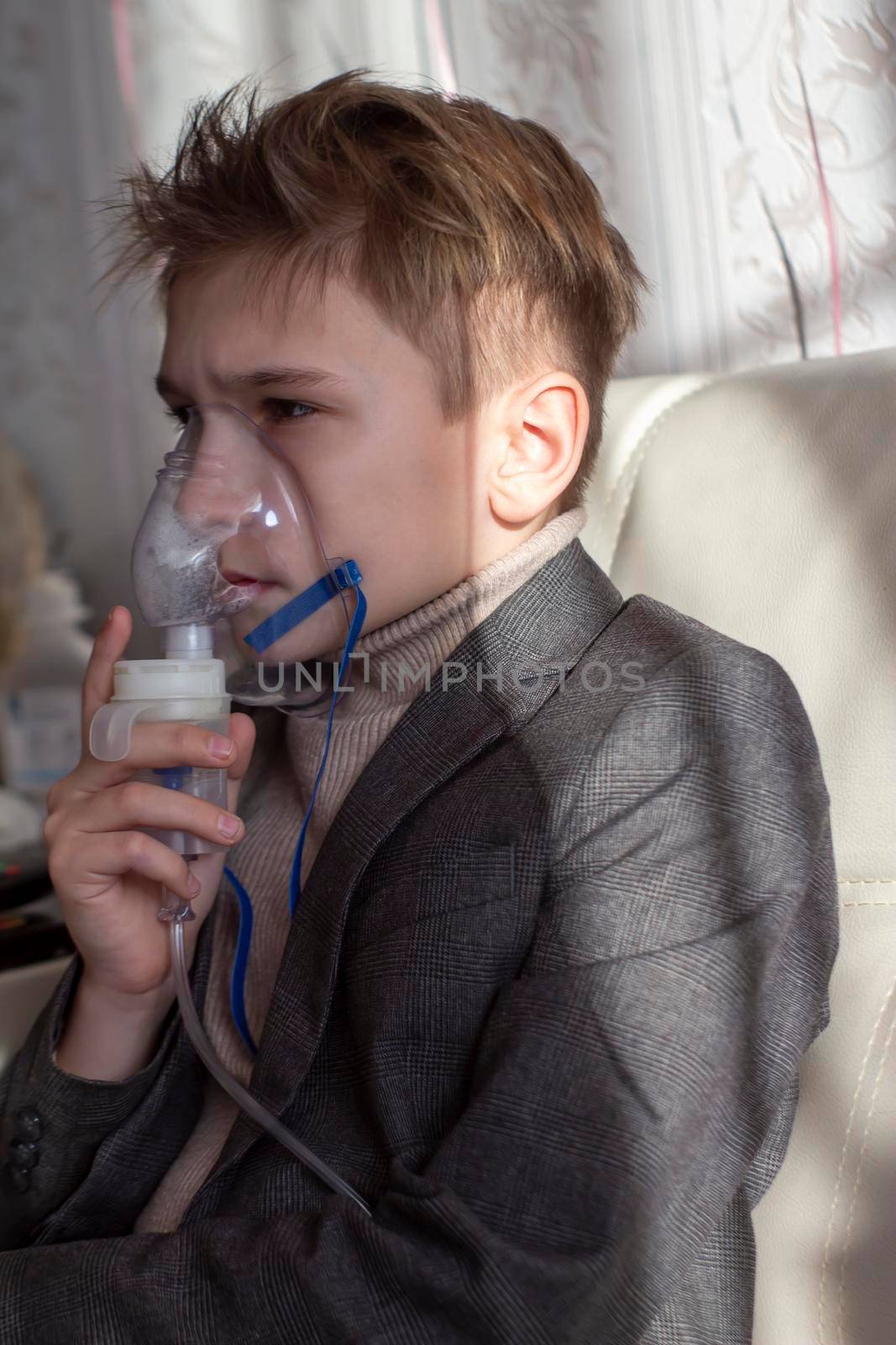Little boy having inhalation for easing cough. Caucasian blonde boy inhales couples containing medication to stop coughing. Medical procedures. Inhaler. Respiratory medicine.