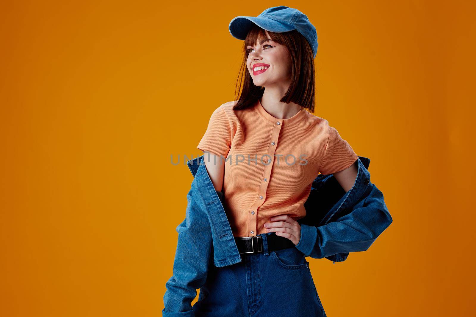 Pretty young female denim clothing fashion posing cap color background unaltered. High quality photo