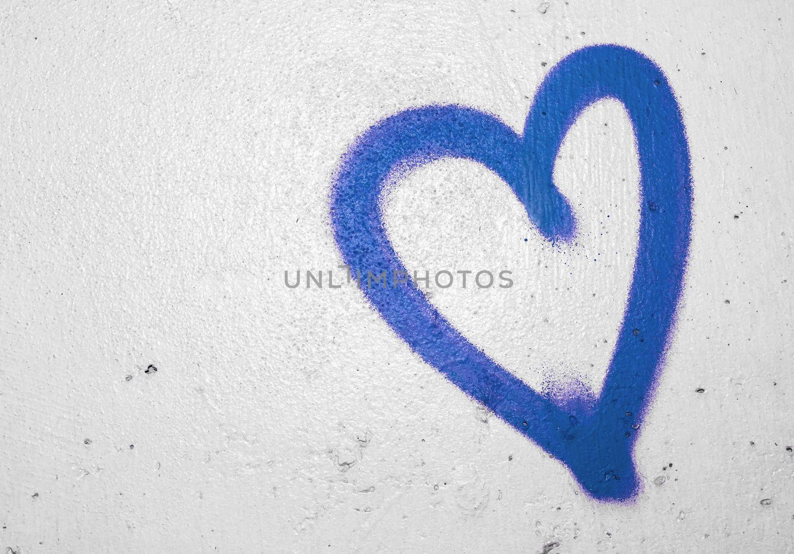 Concept or conceptual painted blue abstract heart shape love symbol, dirty wall background, metaphor to urban and romantic valentine, grungy style.
