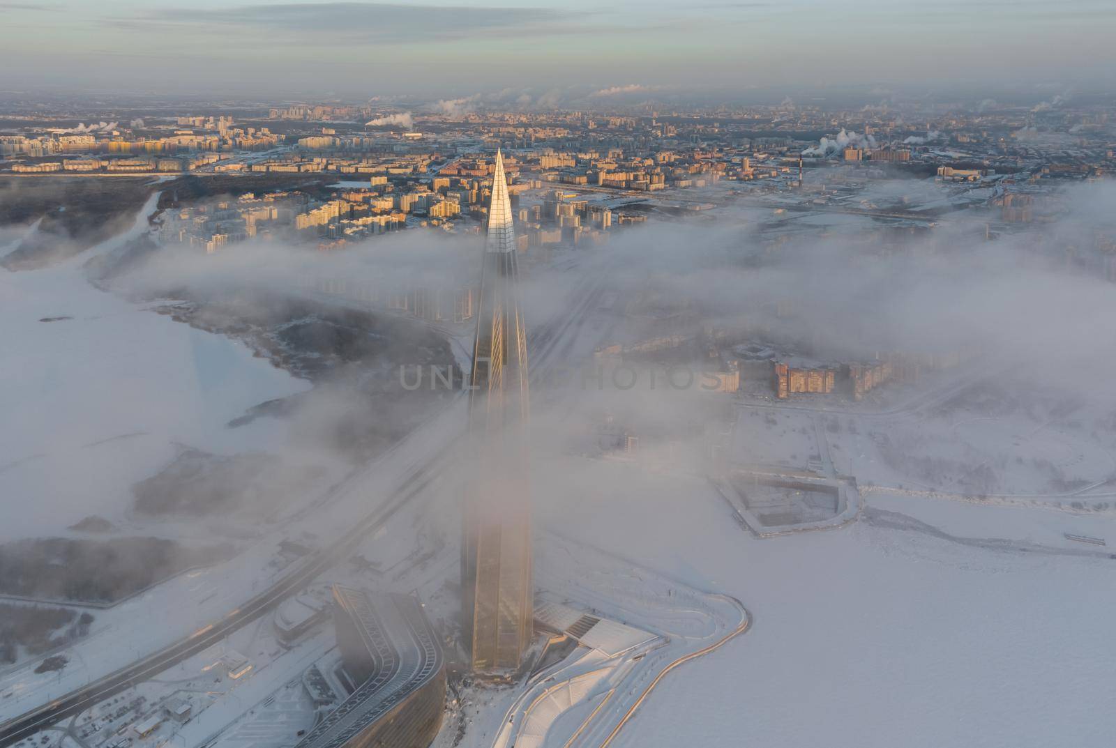 Russia, St. Petersburg, 08 January 2022: Lakhta center skyscraper in a winter frosty evening at sunset, the future main building of the office of the oil company Gazprom, buildings of pink color. High quality photo