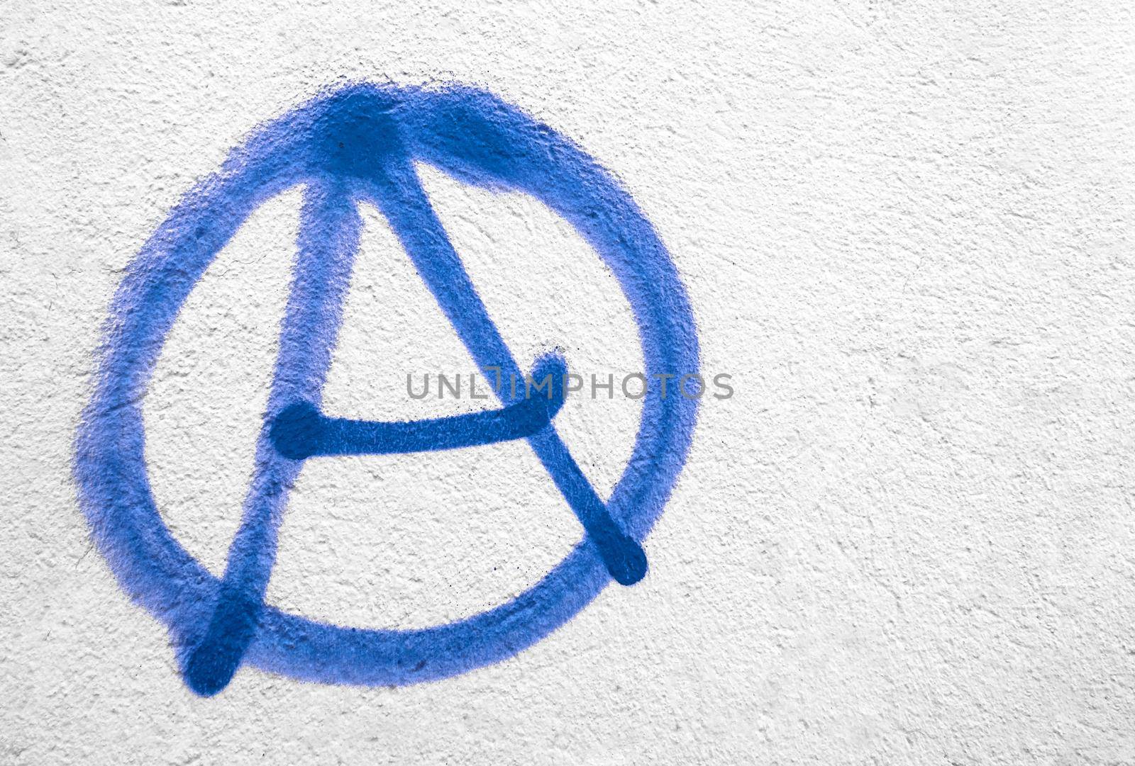 Blue anarchy symbol on wall. Ideal for textures, backgrounds and concepts. Copy space.