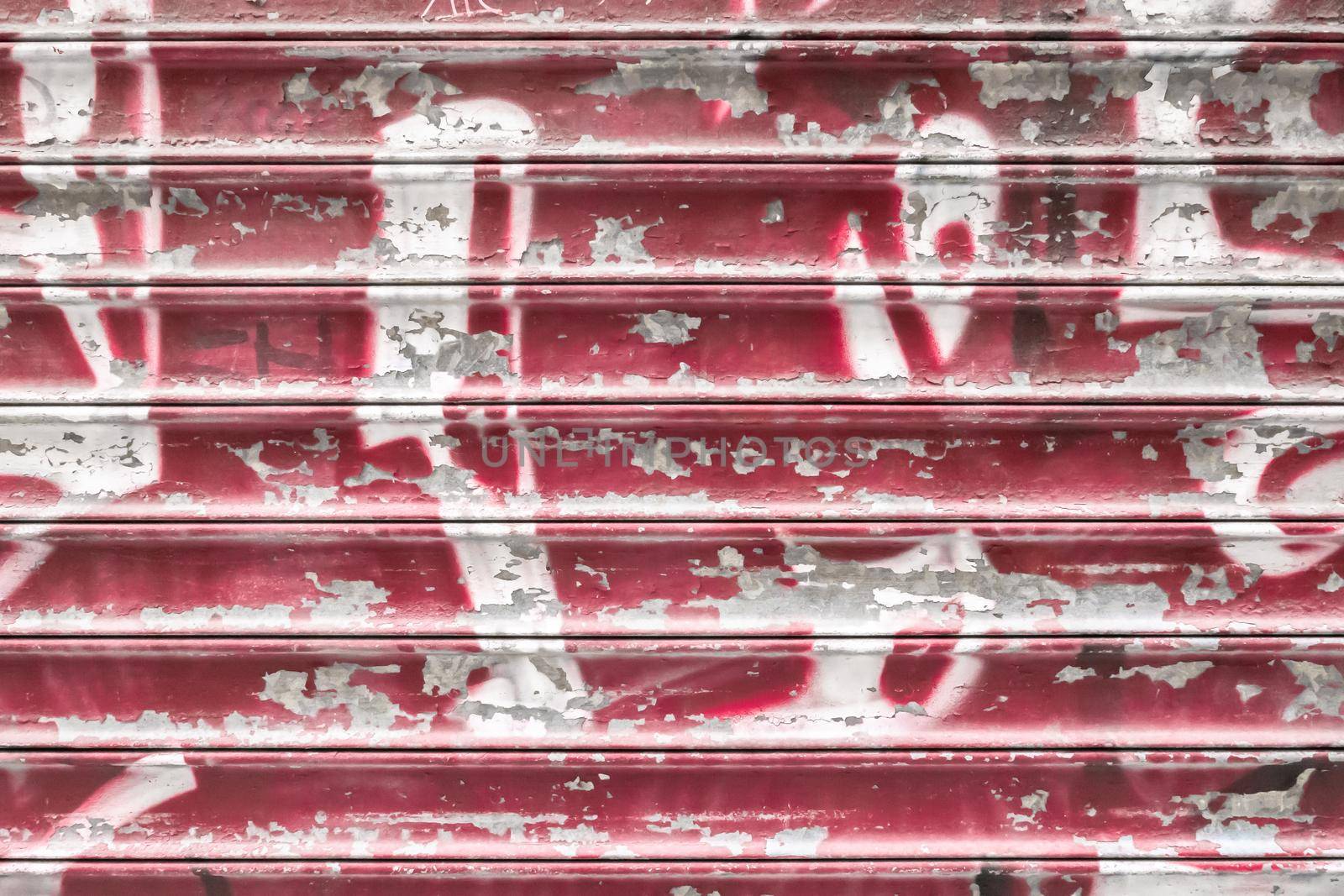 Red metal shutter with peeling paint. Ideal use for background / wallpaper.