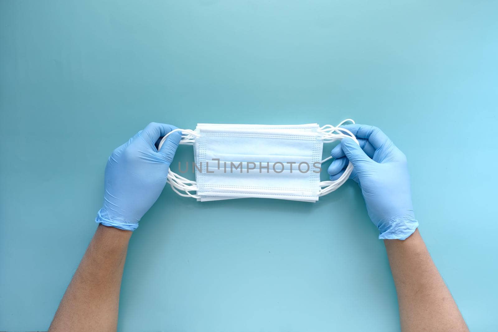 doctor hand in medical glove holding protective surgical face mask, close up .
