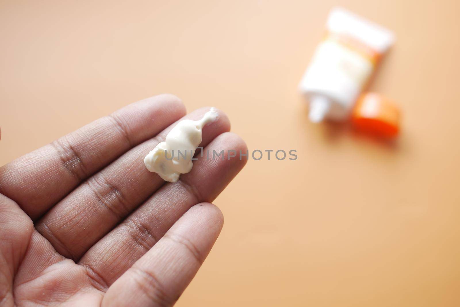 Close up of sunscreen cream on hand .