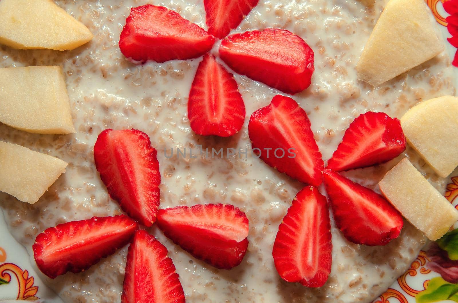 Milk oatmeal on a plate with fruits, strawberries and apples by Sergey