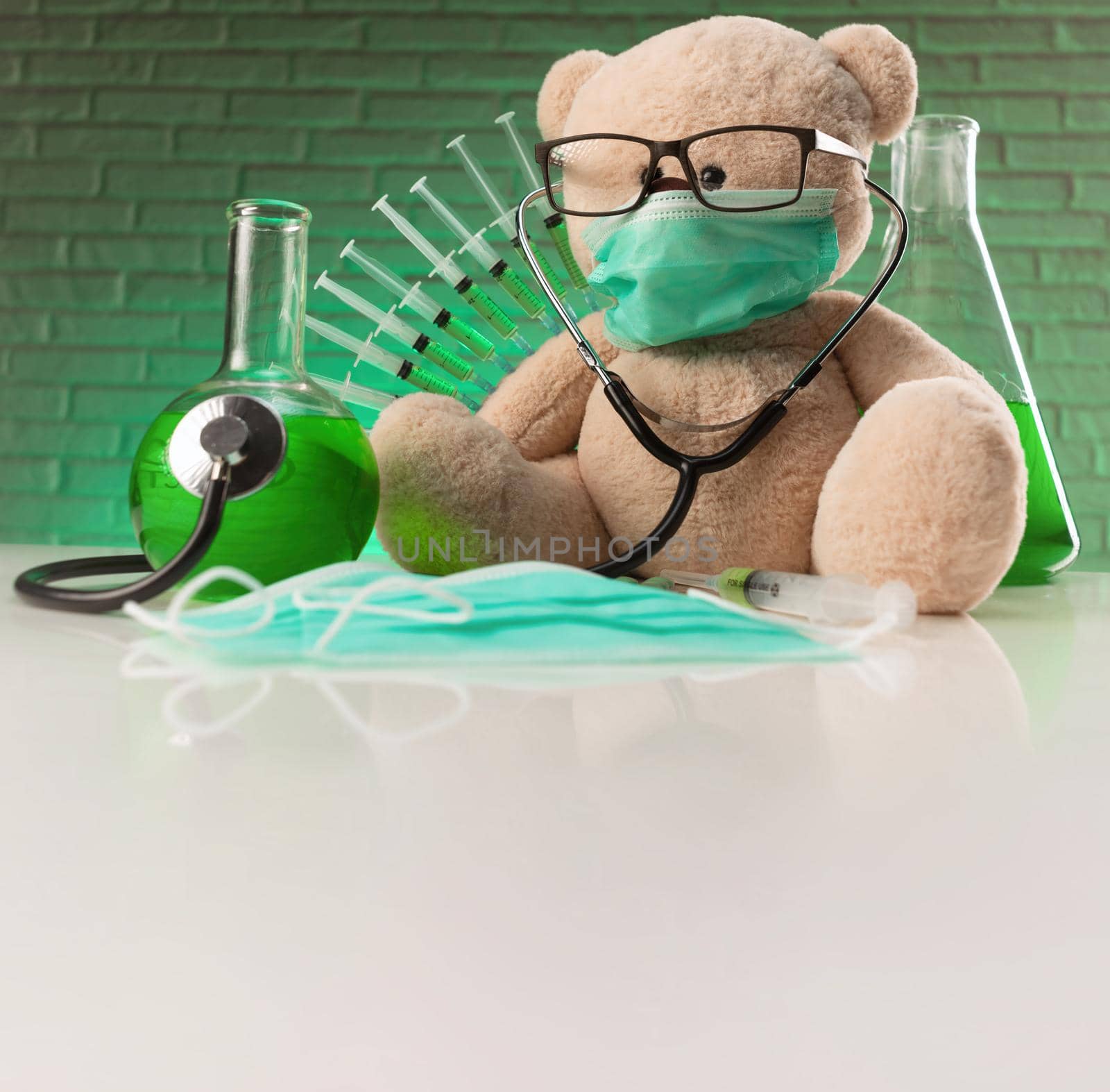 a teddy bear in a medical mask with syringes in his shoulder as a symbol of the research of vaccines and other drugs on animals or people