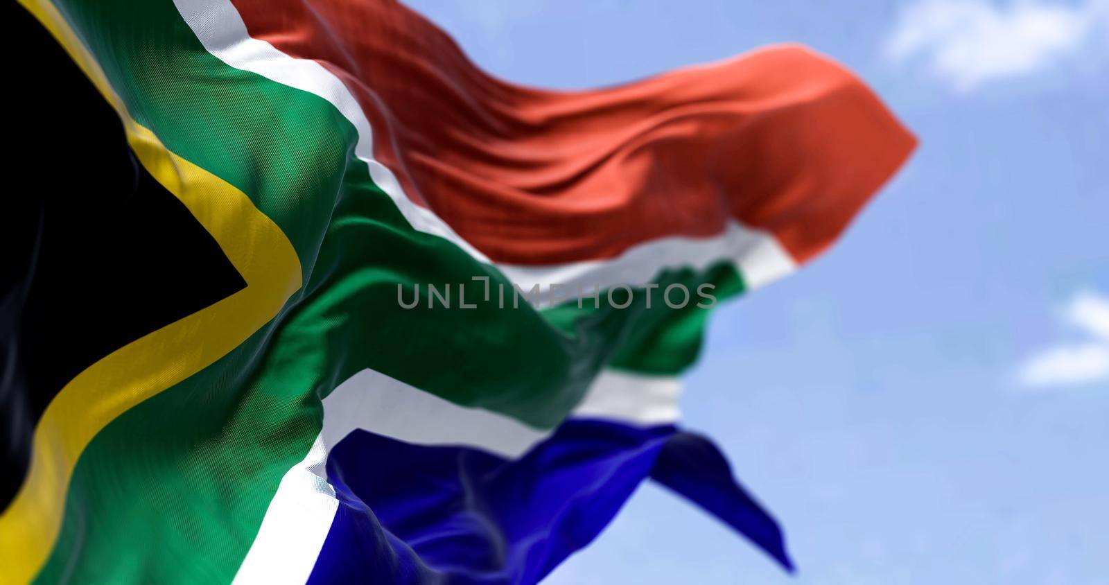 Detailed close up of the national flag of South Africa waving in the wind on a clear day. Democracy and politics. African country. Selective focus.
