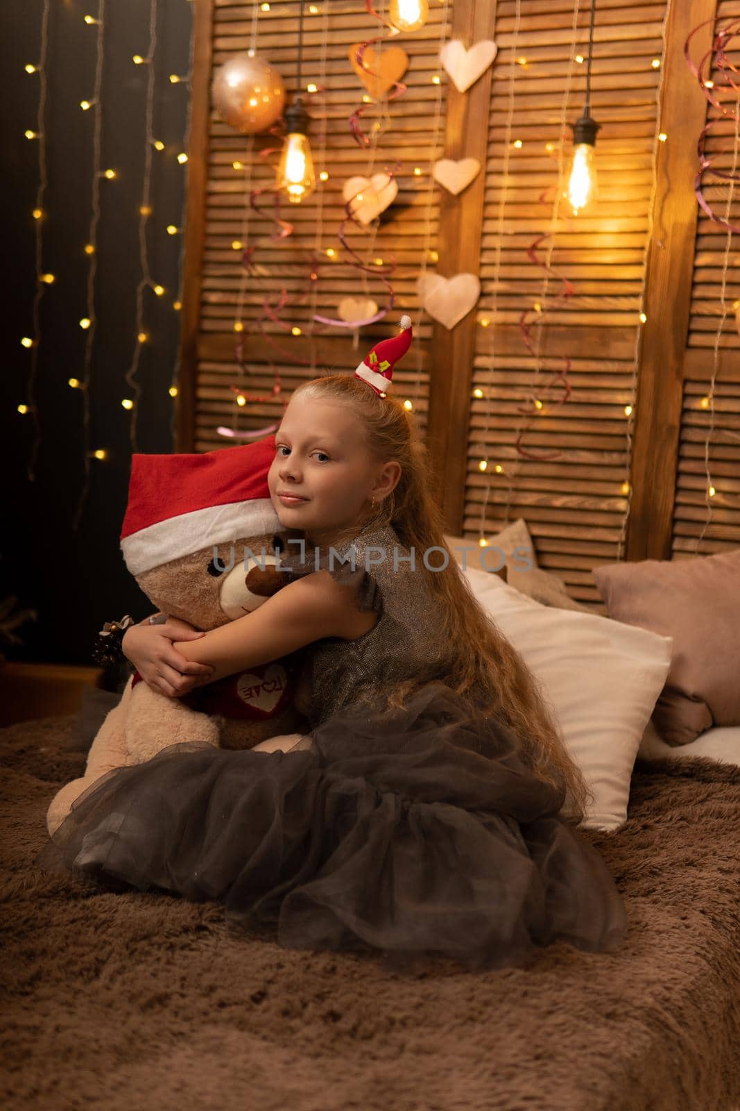 A girl hugs a bear toy in a Christmas cap bear Christmas kid childhood little, for toy home from person lifestyle beautiful, small plush. Pillow woman happiness, blanket wake by 89167702191