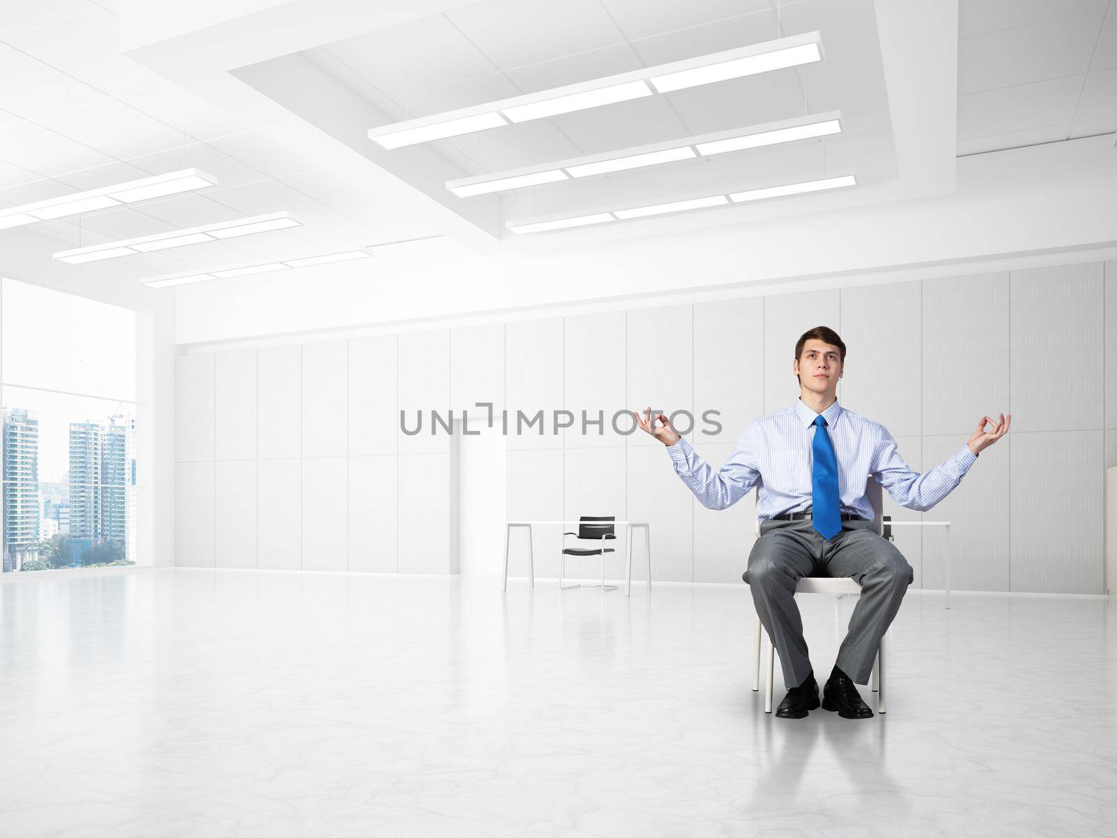 young businessman in the office meditates, achieve calmness, to achieve the goal