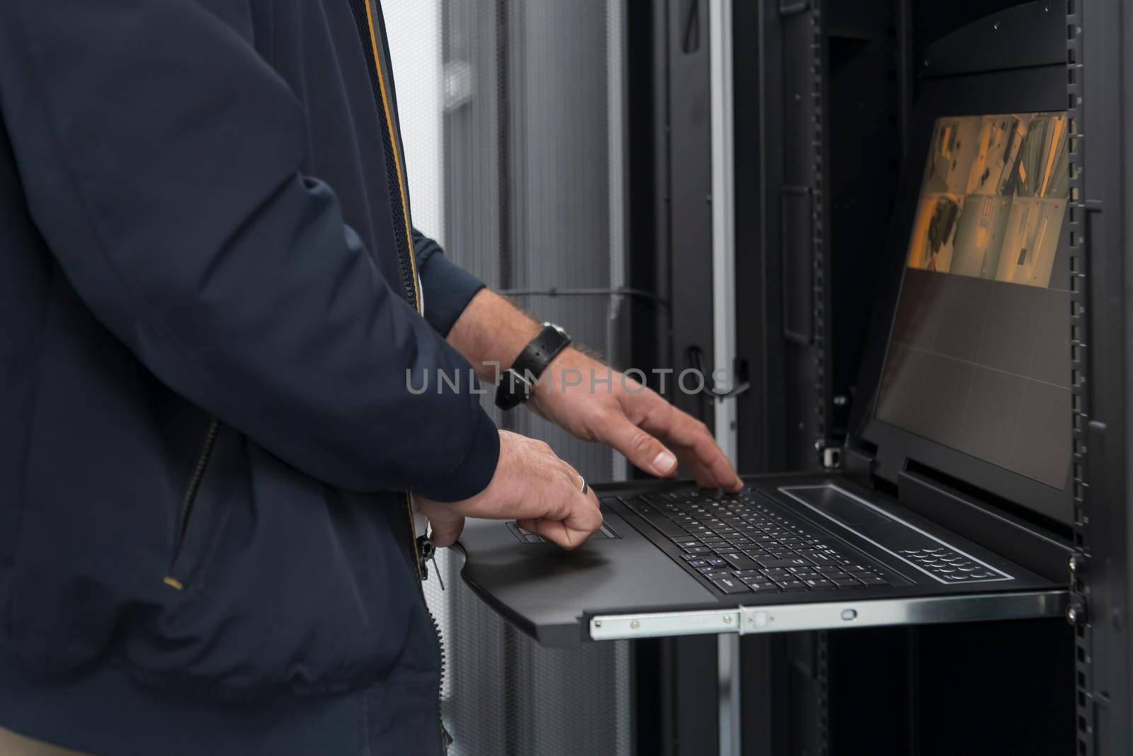 Close up on Data Center Engineer hands Using keyboard on a supercomputer. Server Room Specialist Facility with Male System Administrator Working with Data Protection Network for Cyber Security.