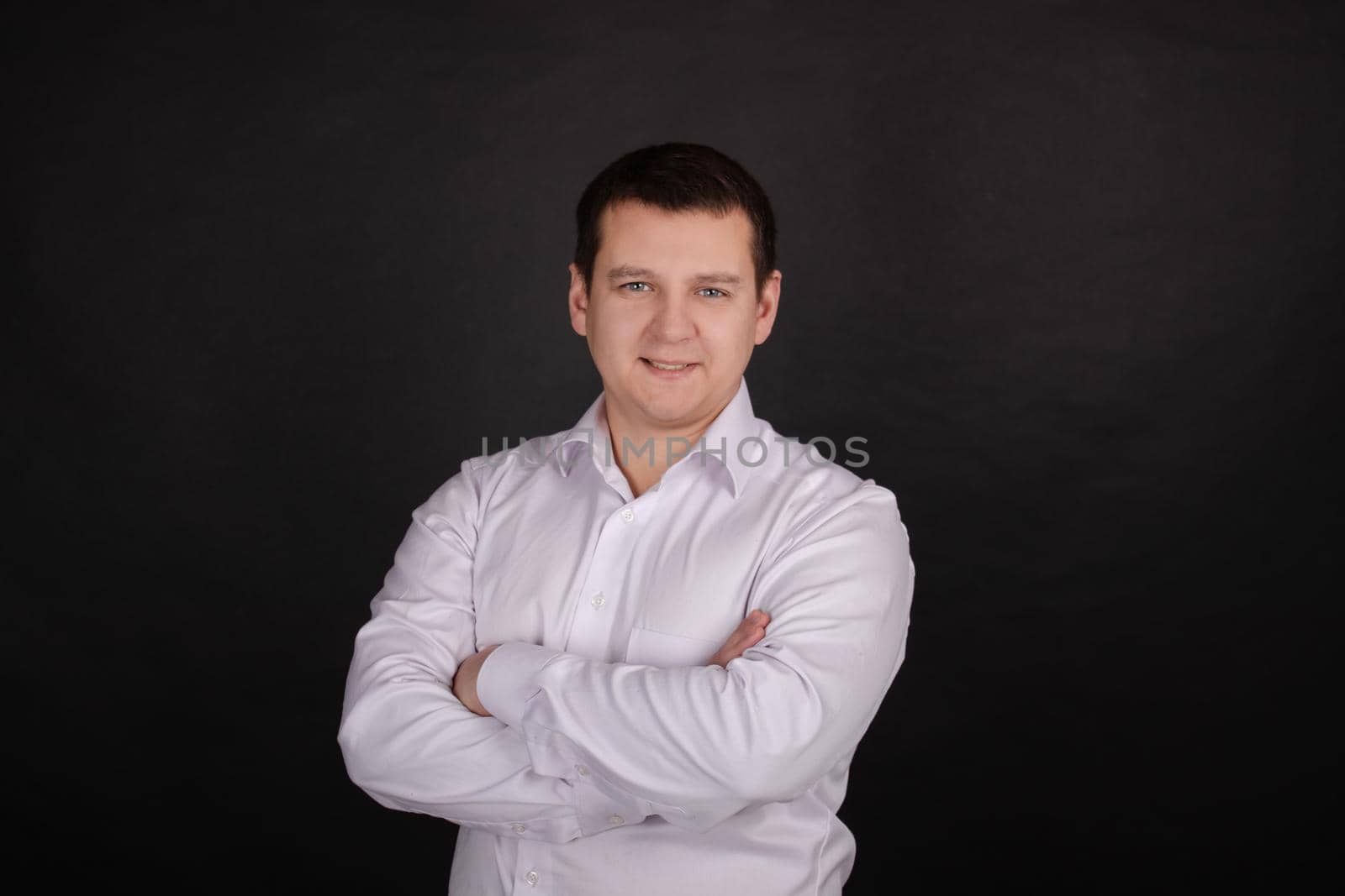 portrait of a handsome man in a white shirt on a black background. business style, office wear. businessman.