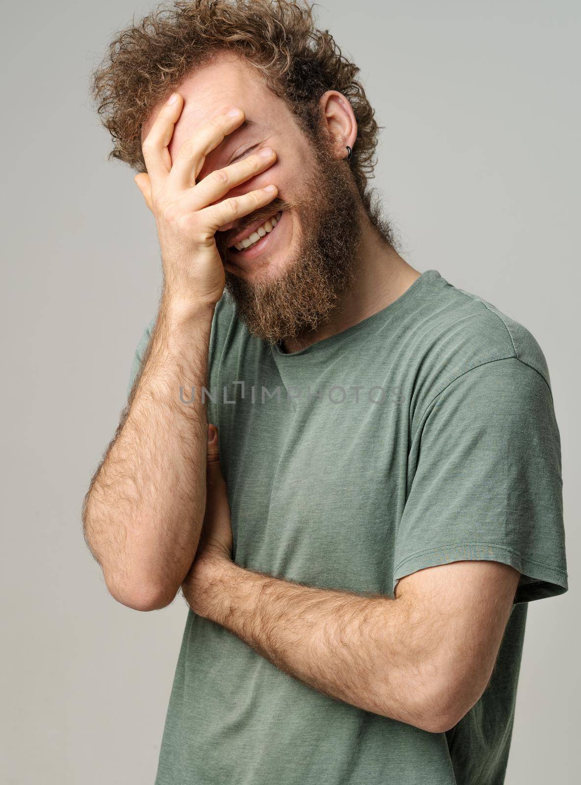 Cheerful Man in Gray T-shirt Laughing on White Background, Guy Enjoys Chatting, Nice Conversation, Positive Day. Close-up by LipikStockMedia