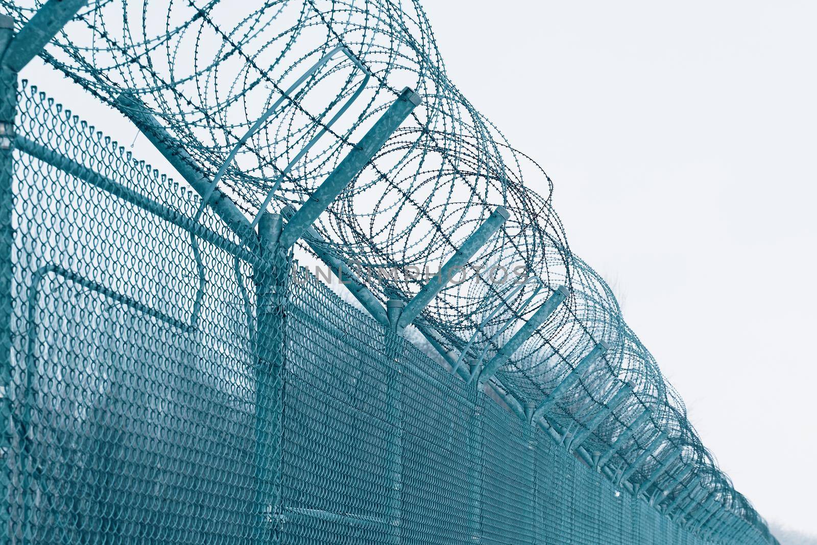 Barbed wire. Security measures for prisoners in prison. Prison fence against blue sky.