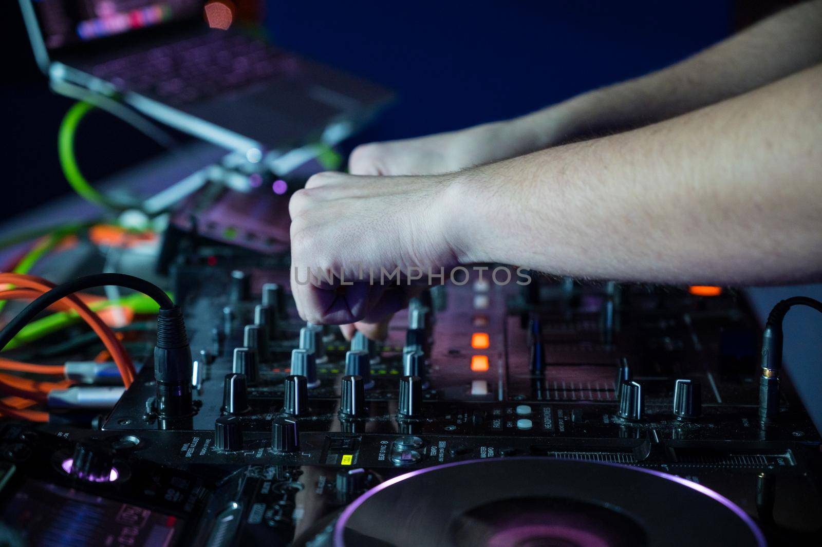 Close-Up of Dj Mixer Controller Desk in Night Club Disco Party. DJ Hands touching Buttons and Sliders Playing Electronic Music . by HERRAEZ