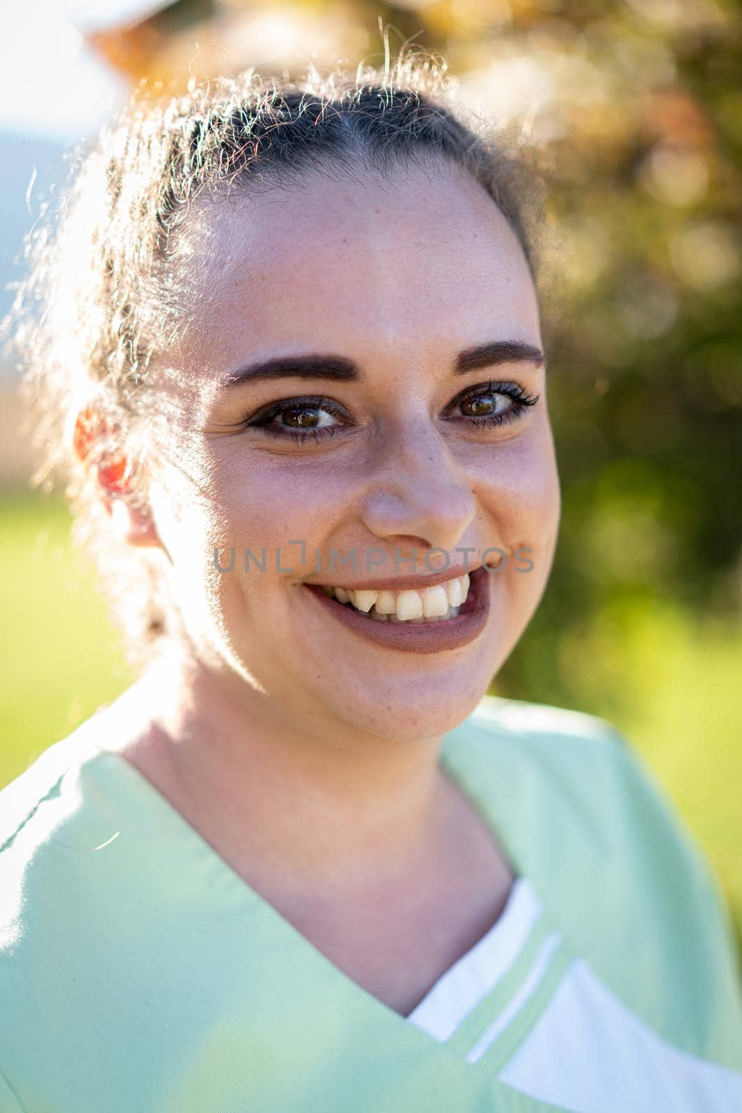 Portrait of nurse with green uniform outdoors by Zurijeta