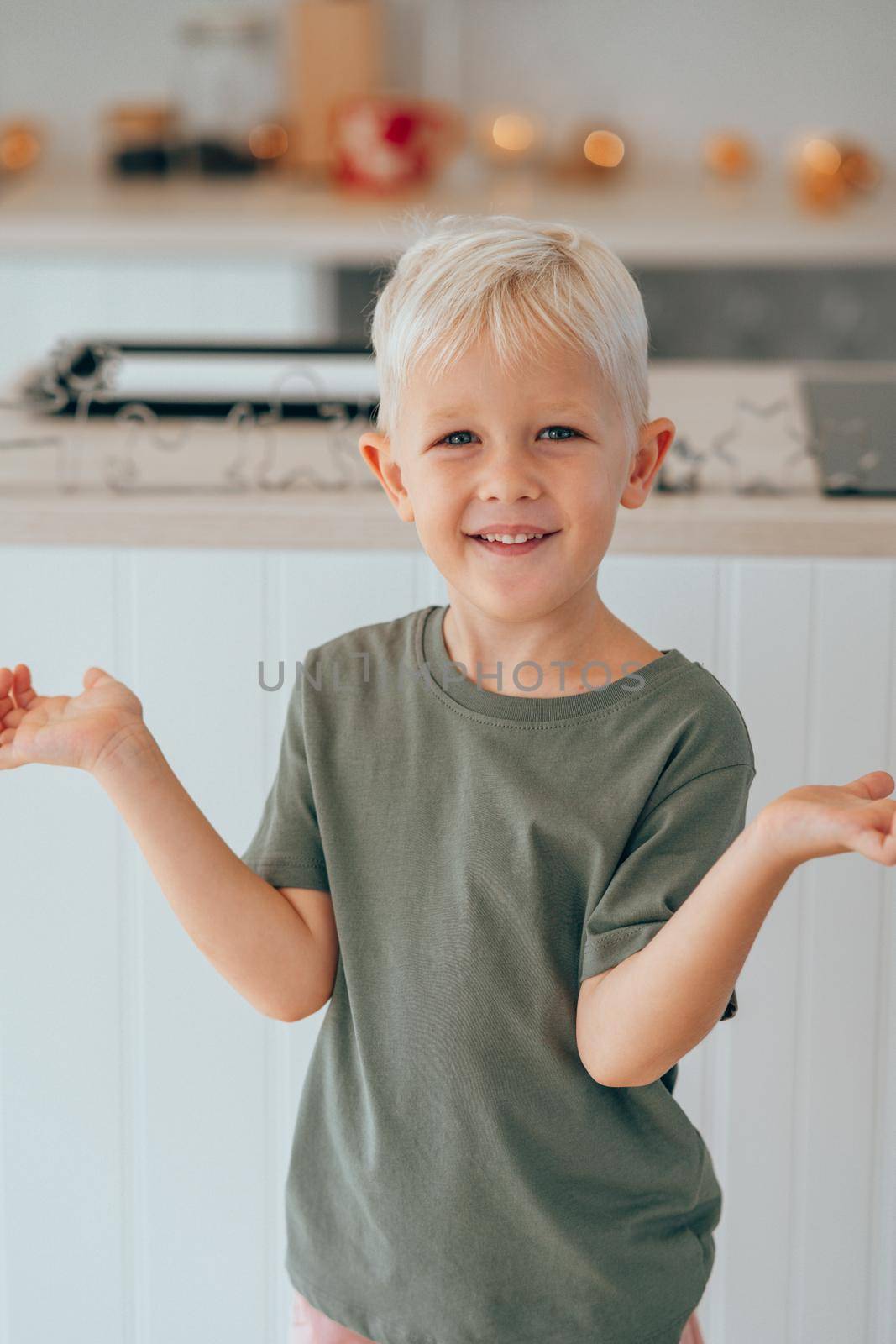 Little boy is standing and ready to bake a Christmas cookies at home. by XGroup