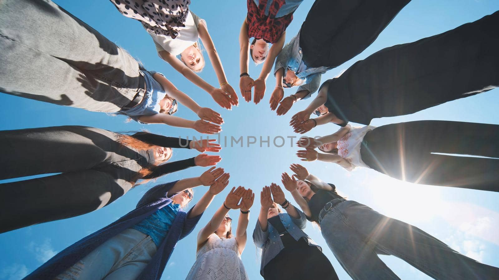 Eleven girls make a circle from their palms. by DovidPro