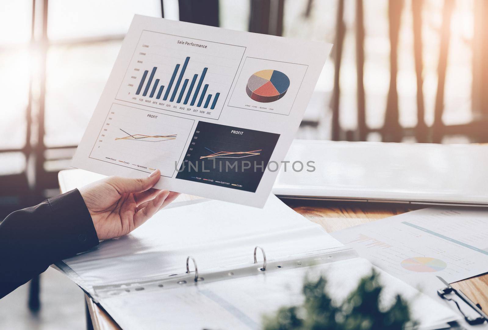 Sales Profitability Planning Ideas, Businesswomen are analyzing profitability statistical graphs from the graph document in hand to plan profits in growth from last year
