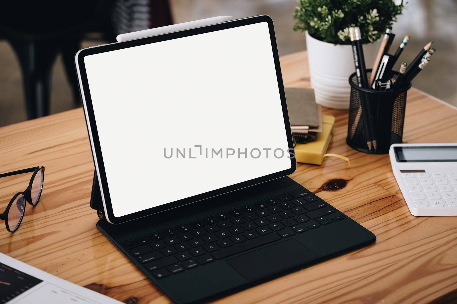 A white screen tablet computer placed on the desk at work. Can put text or media in the area on the white screen