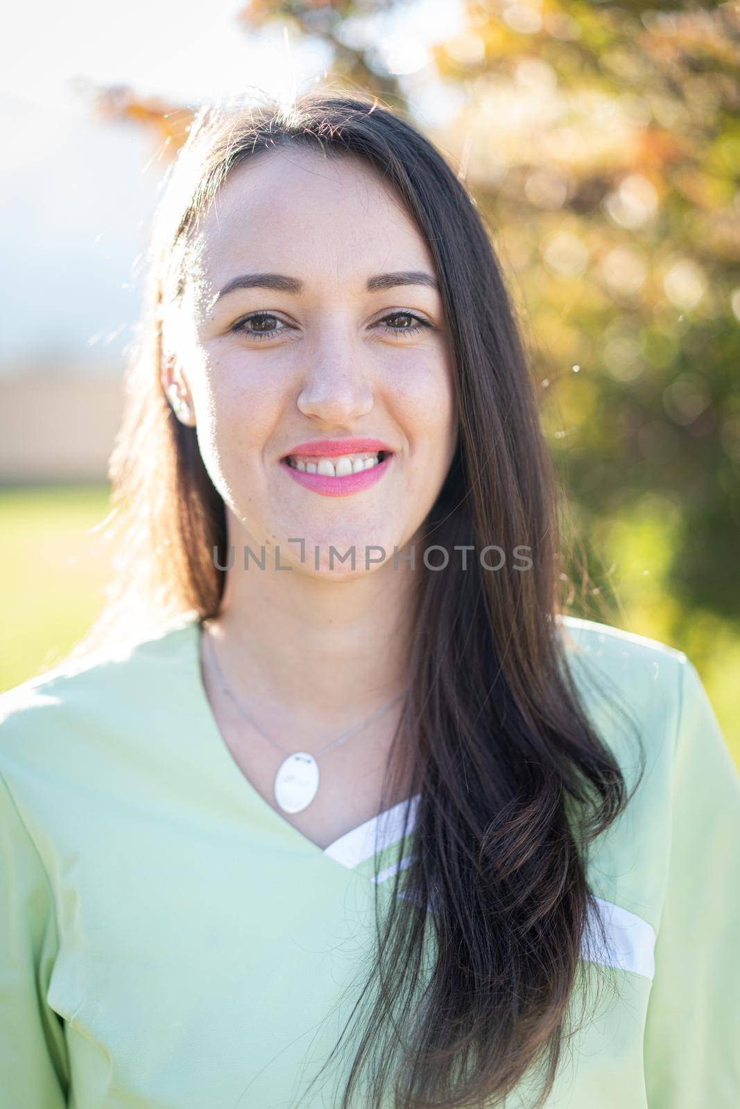 Portrait of nurse with green uniform outdoors by Zurijeta