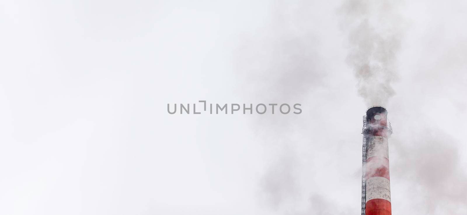 White thick smoke from the boiler room chimney. Industrial zone.Banner by AnatoliiFoto