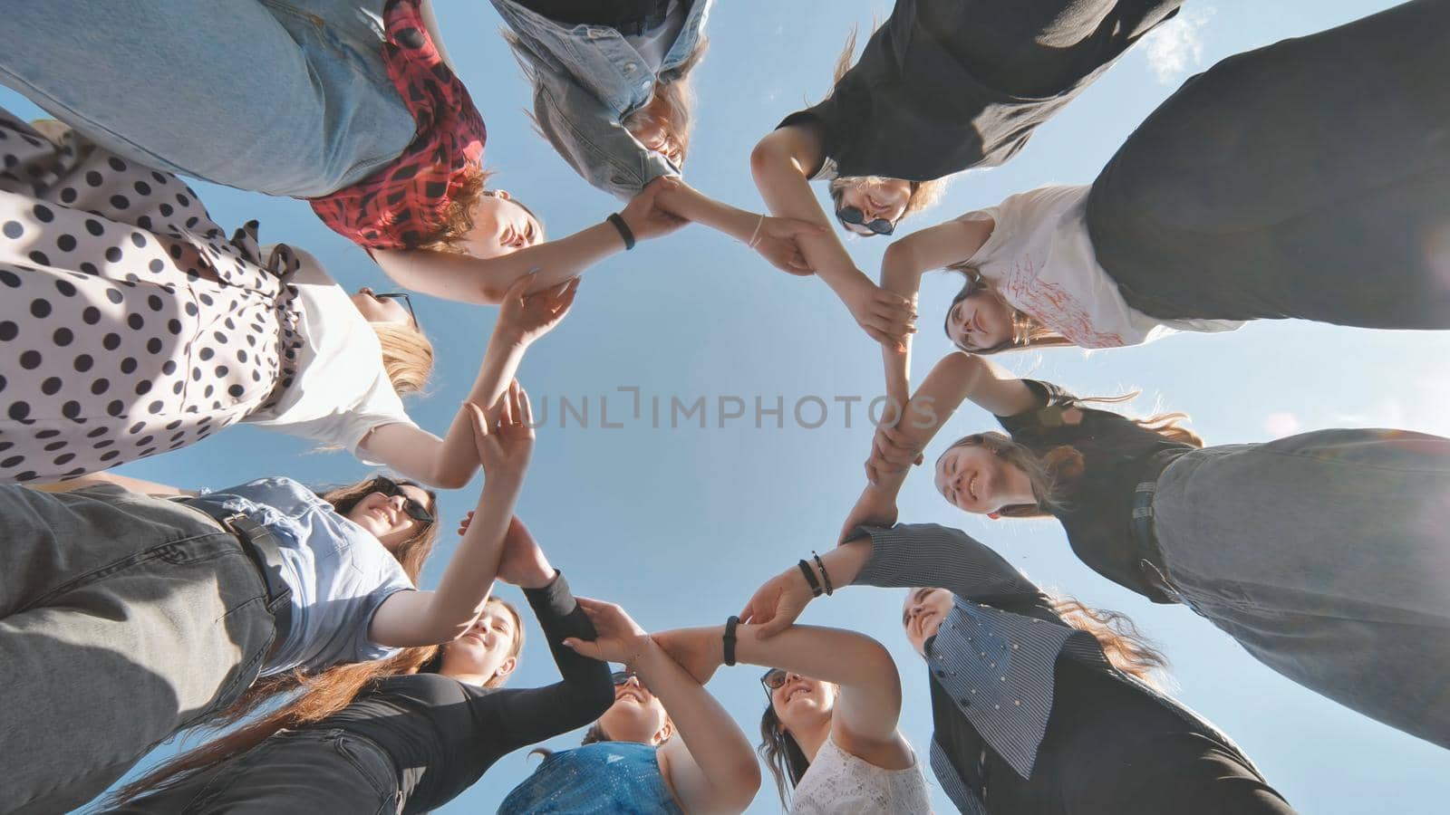 A group of girls makes a circle shape holding each other's hands