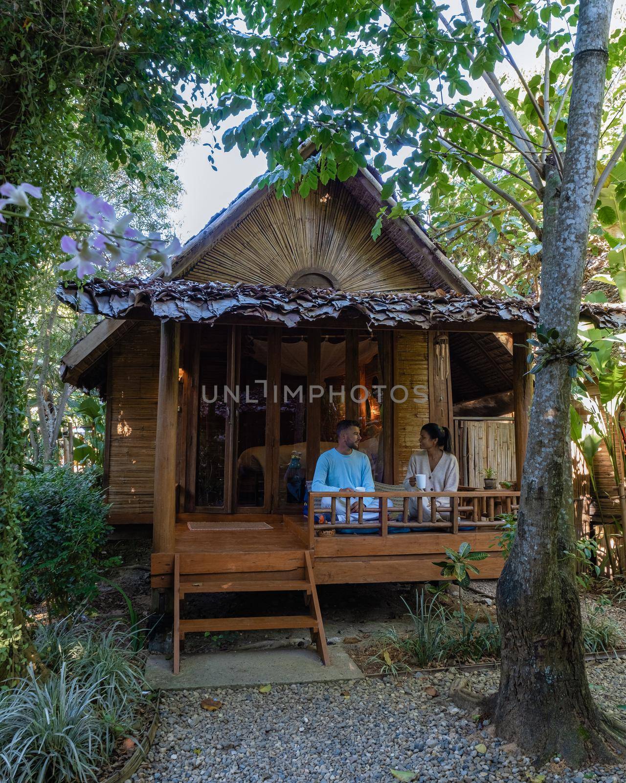 couple man and women in front of a bamboo hut in Northern Thailand. man and woman on vacation in Thailand