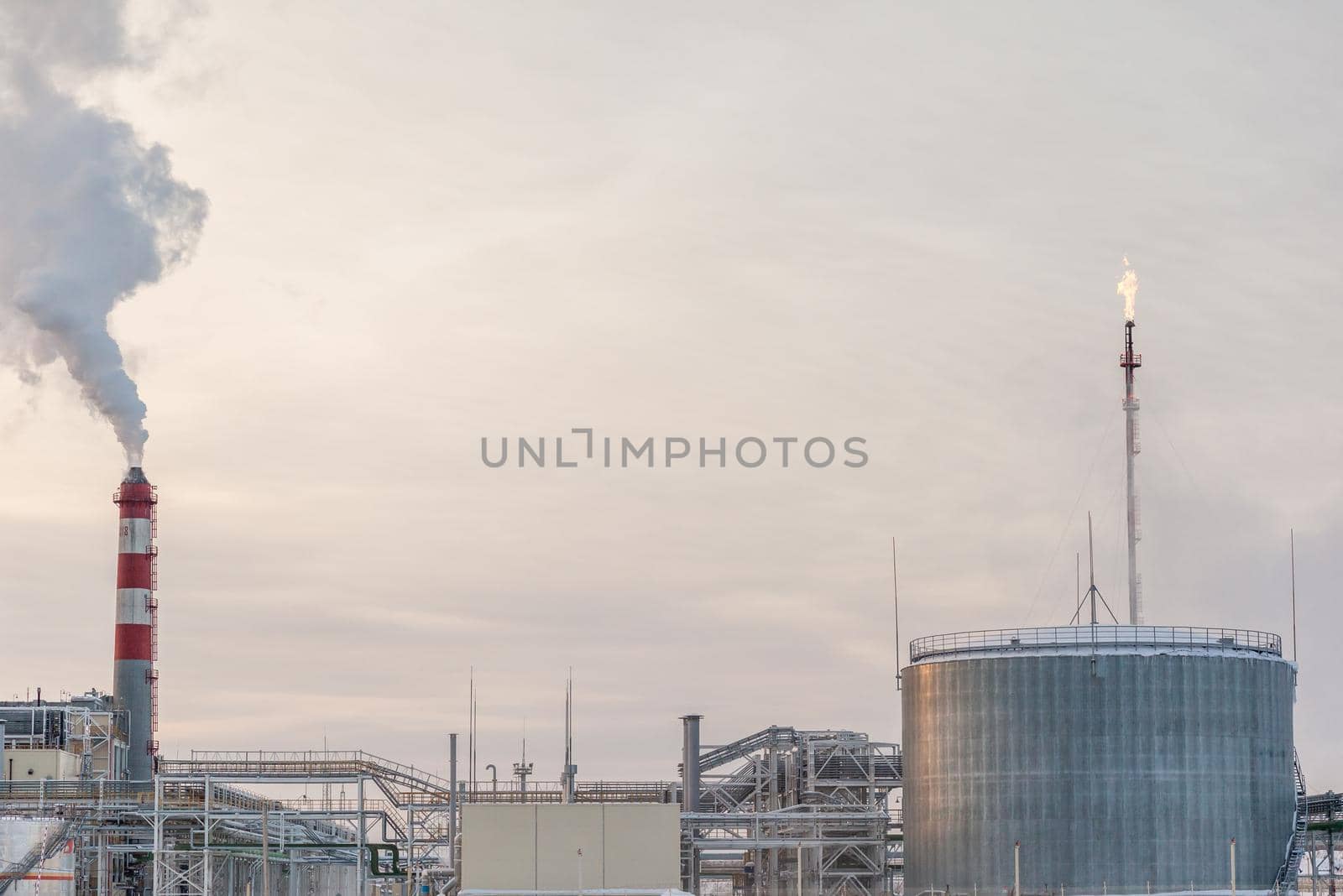 The work of a petrochemical plant. Smoke is coming from the chimney. by AnatoliiFoto