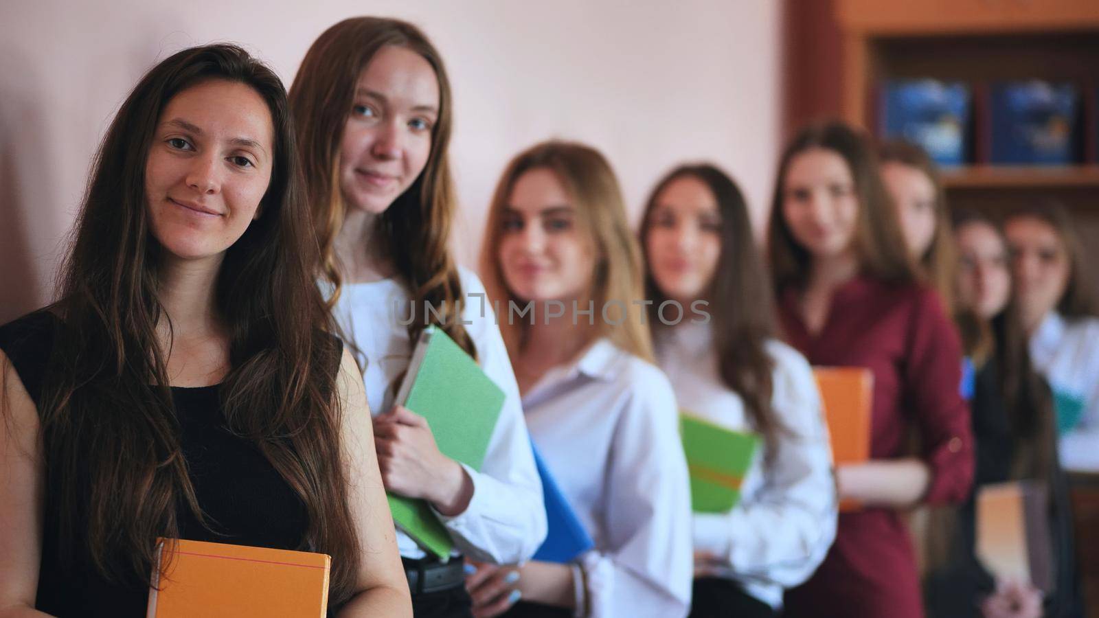 High school students are in a row in the classroom with textbooks