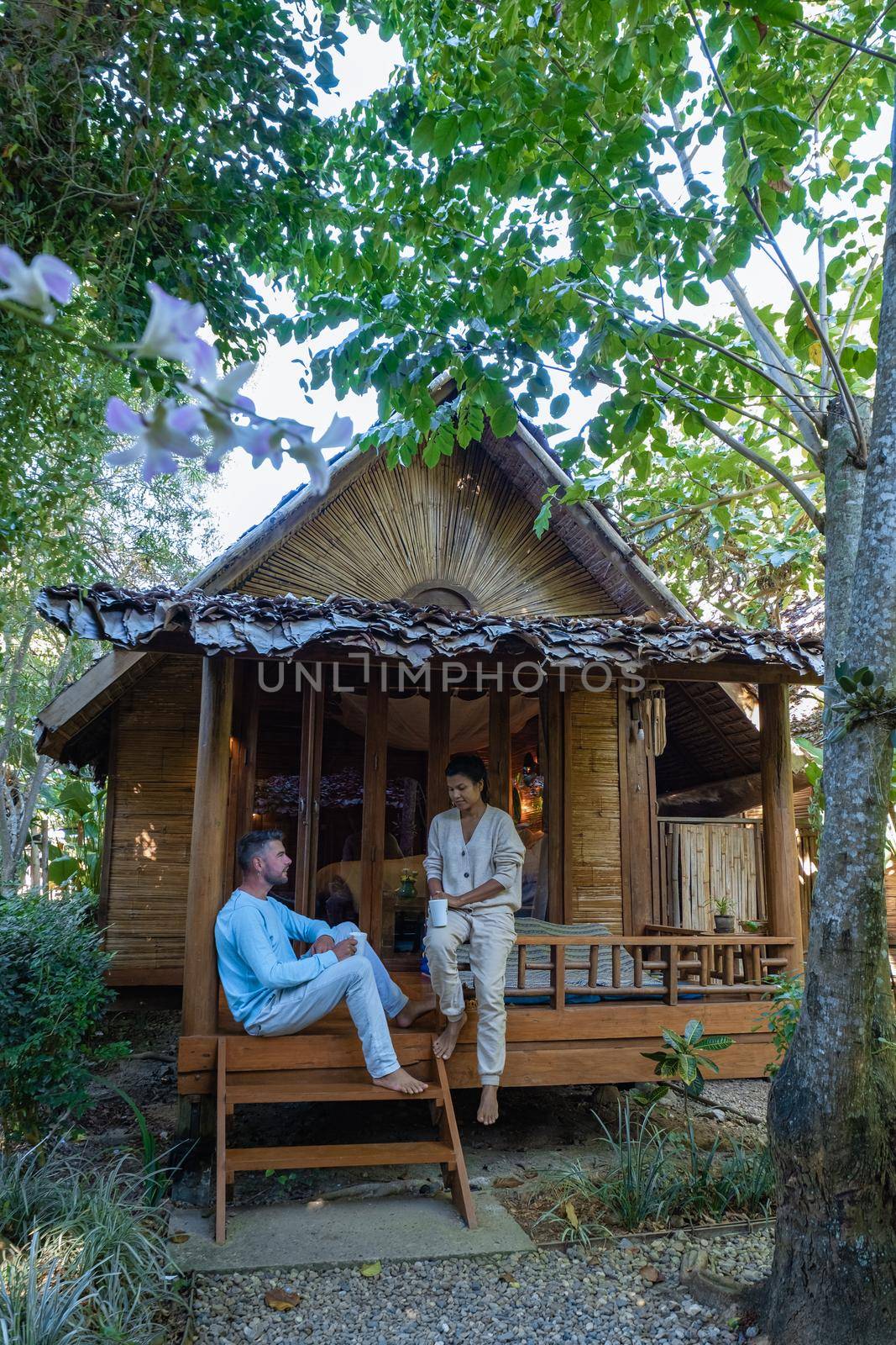 couple man and woman in front of bamboo hut in Northern Thailand by fokkebok