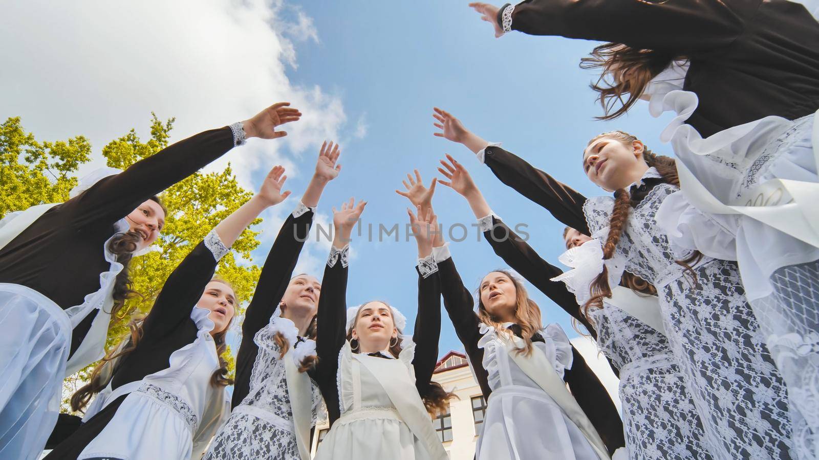 Happy Russian graduates join their hands on the last day of the school day. by DovidPro